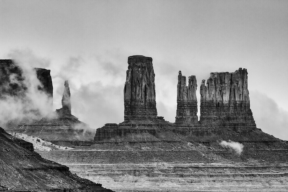 Tief hängende Wolken um die Utah-Monumente im Monument Valley, Monument Valley Navajo Tribal Park, Arizona. LR: der König auf seinem Thron, das Schloss, der Bär und der Hase und die Postkutsche