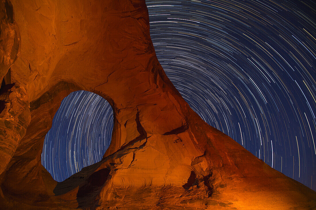Star trails over the Ear of the Wind Arch at night in the Monument Valley Navajo Tribal Park in Arizona.