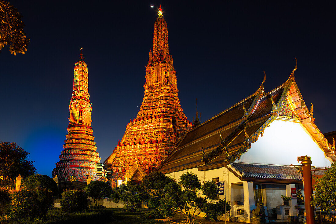 Mondsichel über dem Wat Arun oder Tempel der Morgenröte, einem buddhistischen Tempel in Bangkok, Thailand, mit seinen Prangs oder Türmen im Khmer-Stil