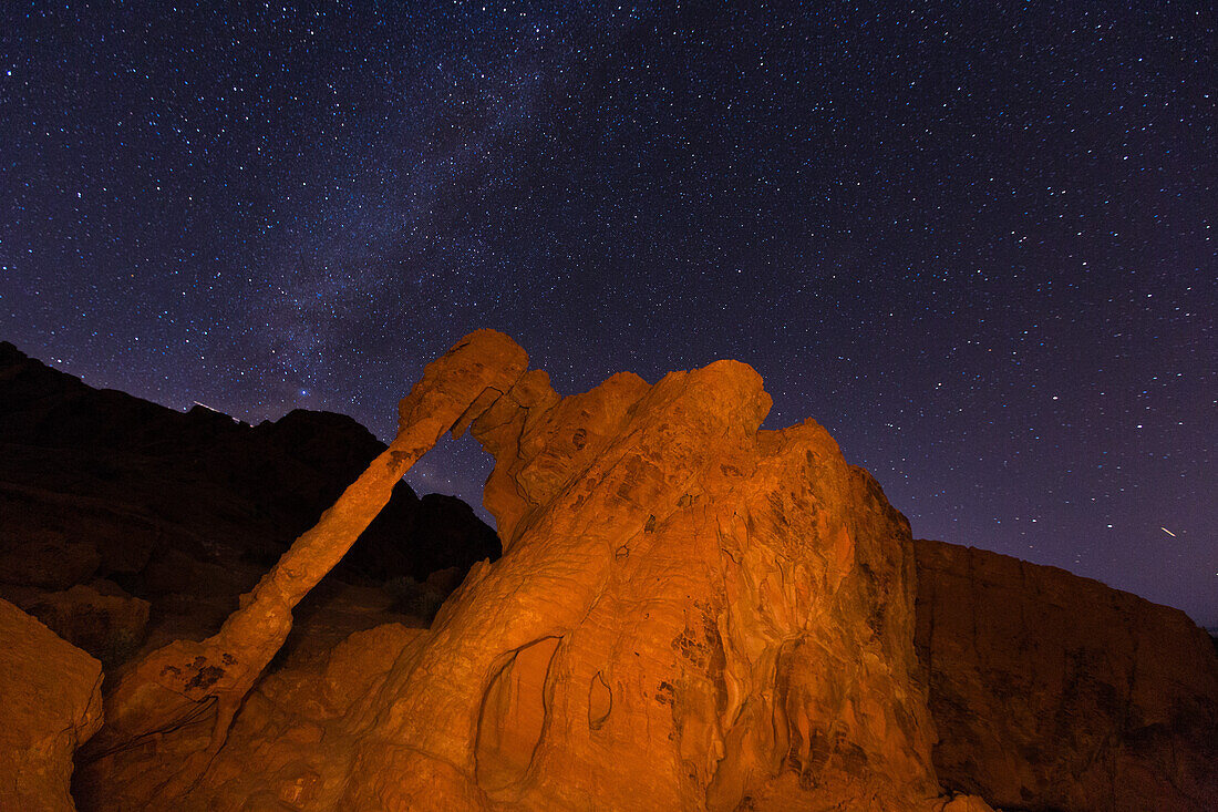 Milchstraße über dem Elephant Rock, einem natürlichen Bogen im erodierten Azteken-Sandstein bei Nacht im Valley of Fire State Park in Nevada