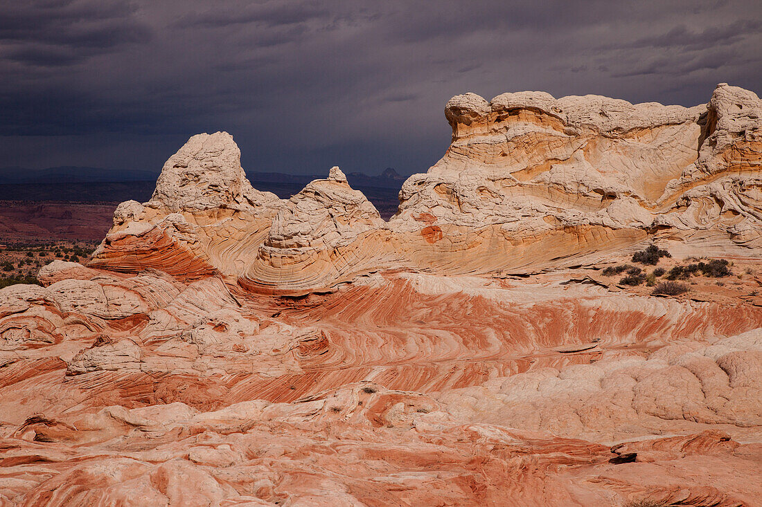 Stürmische Wolken über bunten erodierten Sandsteinformationen. White Pocket Recreation Area, Vermilion Cliffs National Monument, Arizona