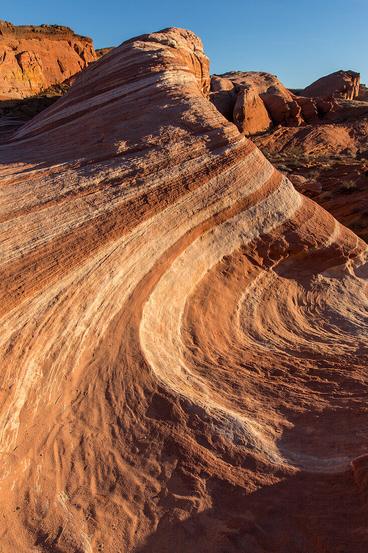 Die Feuerwelle, eine rot-weiß gestreifte aztekische Sandsteinformation bei Sonnenuntergang im Valley of Fire State Park in Nevada