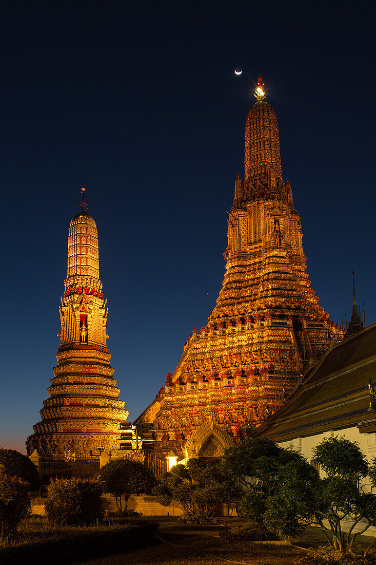 Crescent moon over Wat Arun or Temple of Dawn, a Buddhist temple in Bangkok, Thailand, with its Khmer-style prangs or spires.