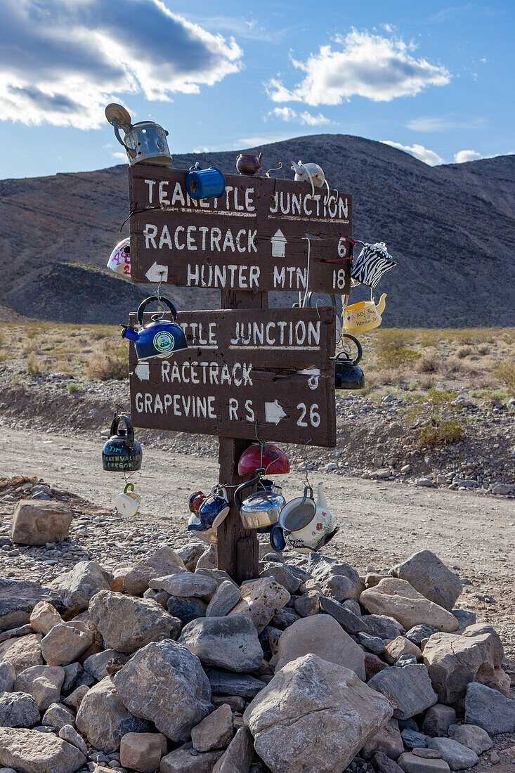 The road sign for Teakettle Junction, covered with tea kettles, in Death Valley National Park, Mojave Desert, California.