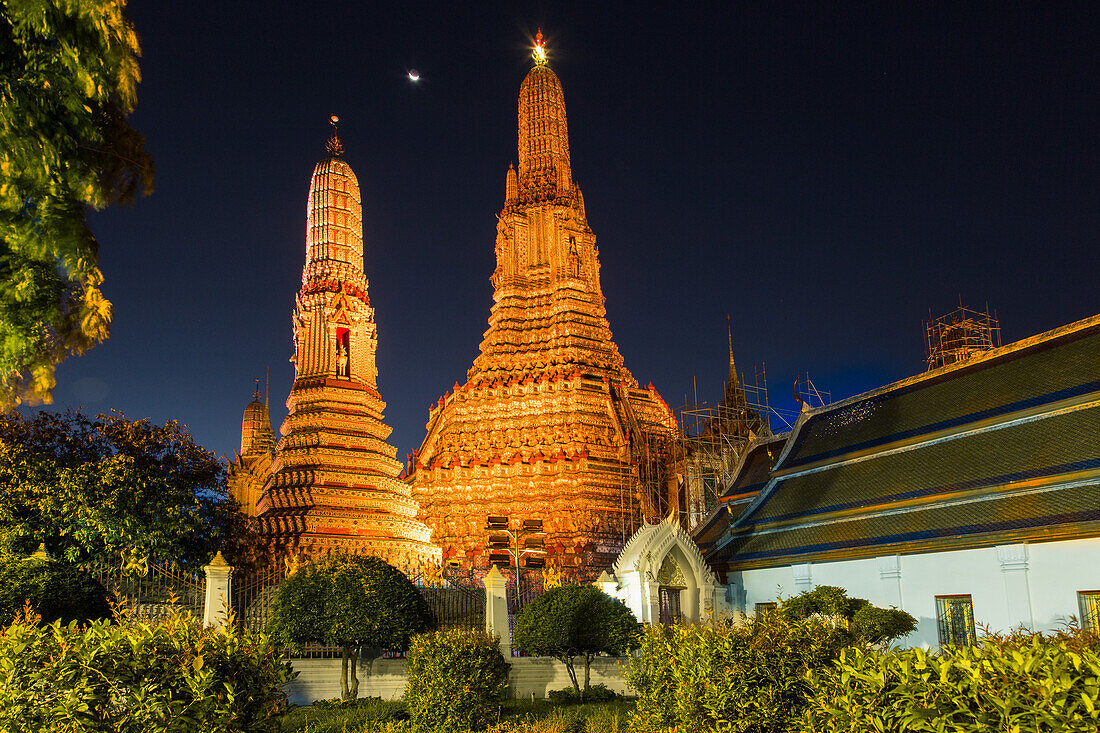 Crescent moon over Wat Arun or Temple of Dawn, a Buddhist temple in Bangkok, Thailand, with its Khmer-style prangs or spires.