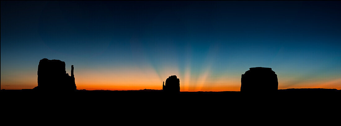 Crepuscular sun rays over the Mittens & Merrick Butte before dawn in the Monument Valley Navajo Tribal Park in Arizona.