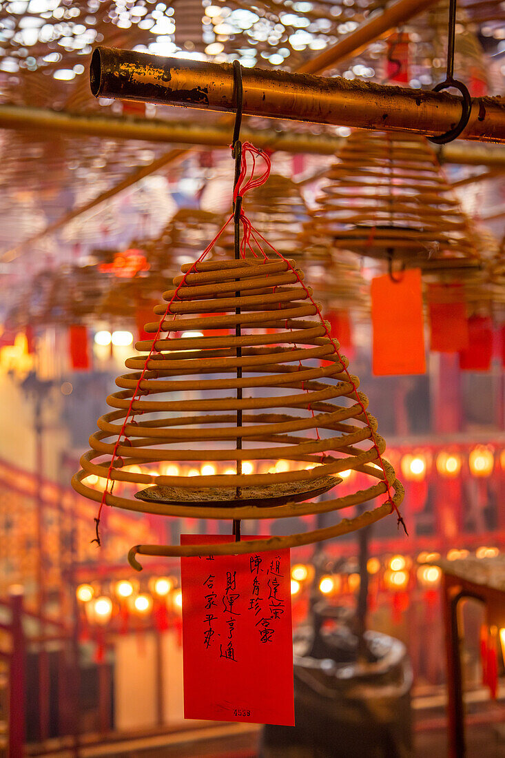 Burning incense coils send prayers to heaven in the Man Mo Temple, a Buddhist temple in Hong Kong, China.