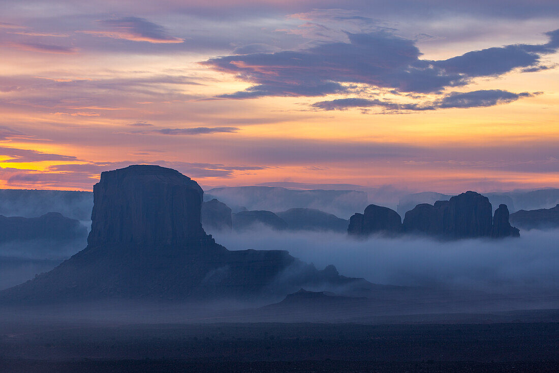 Nebliger Sonnenaufgang am Elephant Butte und Camel Rock im Monument Valley Navajo Tribal Park in Arizona