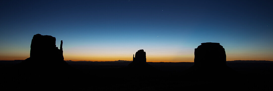 Predawn sky over the Mittens & Merrick Butte before dawn in the Monument Valley Navajo Tribal Park in Arizona.