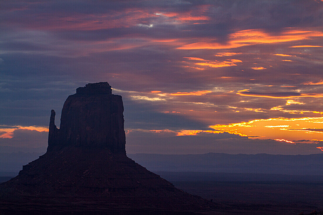 Clouds over the East Mitten Butte at dawn in the Monument Valley Navajo Tribal Park in Arizona.