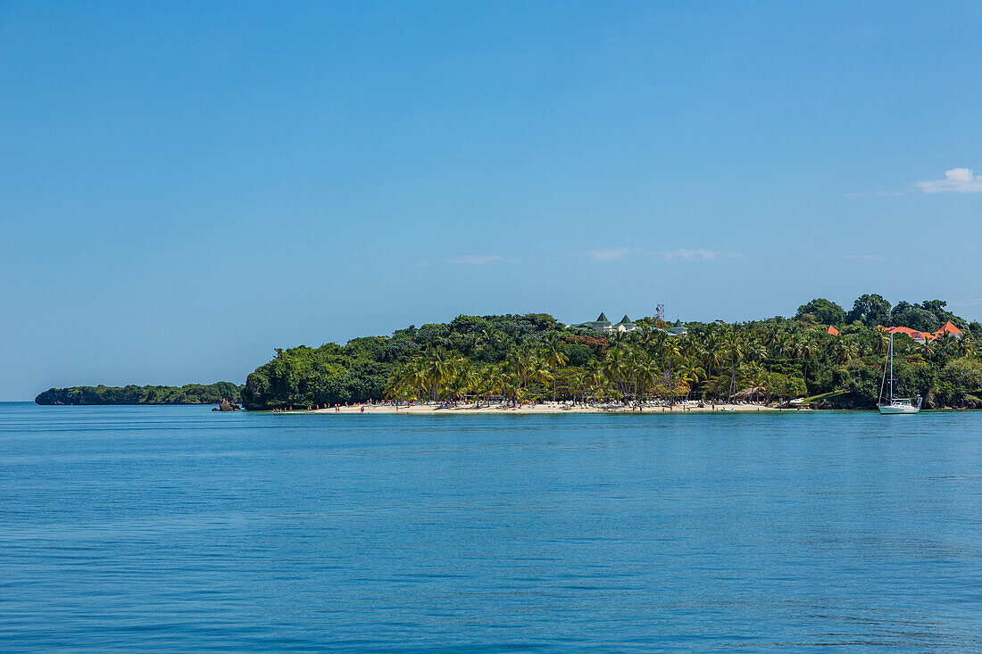 Ein Segelboot und Touristen am Strand von Cayo Levantado, einer Ferieninsel in der Bucht von Samana in der Dominikanischen Republik