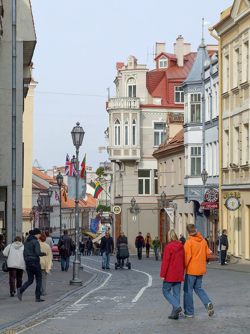 People walk on a street of classic architecture in the historic Old Town of Vilnius, Lithuania. A UNESCO World Heritage Site.
