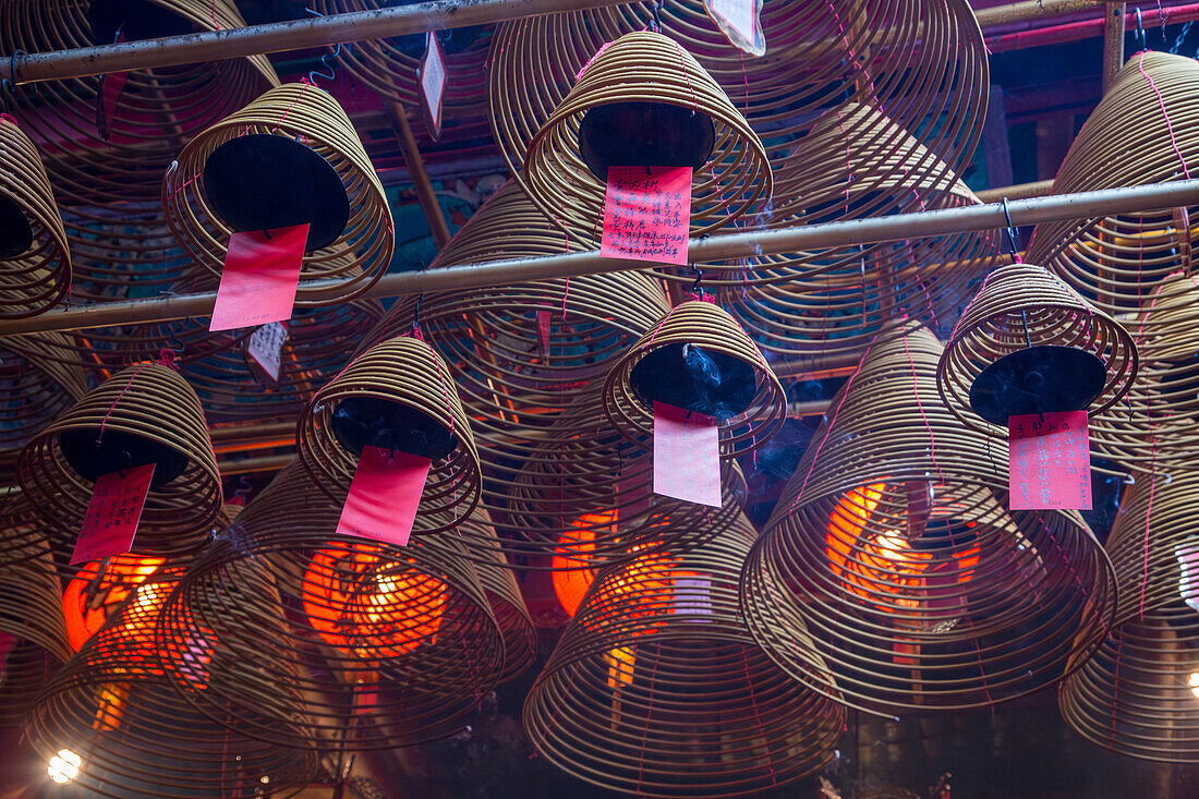 Burning incense coils send prayers to heaven in the Man Mo Temple, a Buddhist temple in Hong Kong, China.