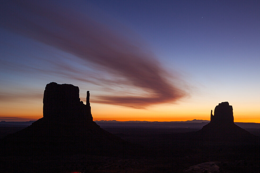 Gebogene Wolke über den Mittens vor Sonnenaufgang im Monument Valley Navajo Tribal Park in Arizona