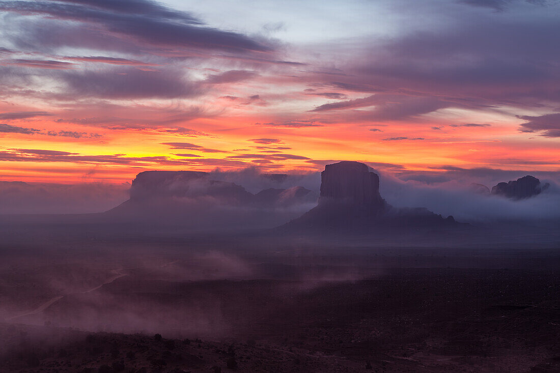 Colorful sunrise over Elephant Butte & Spearhead Mesa in the Monument Valley Navajo Tribal Park in Arizona.