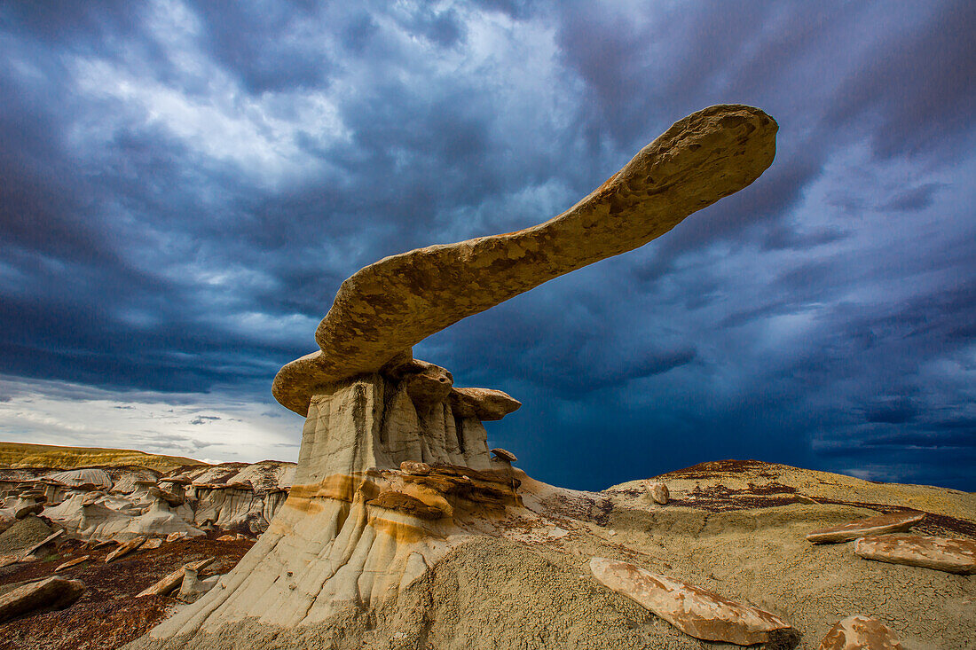 The King of Wings, a very fragile sandstone hoodoo in the badlands of the San Juan Basin in New Mexico, with storm clouds behind.