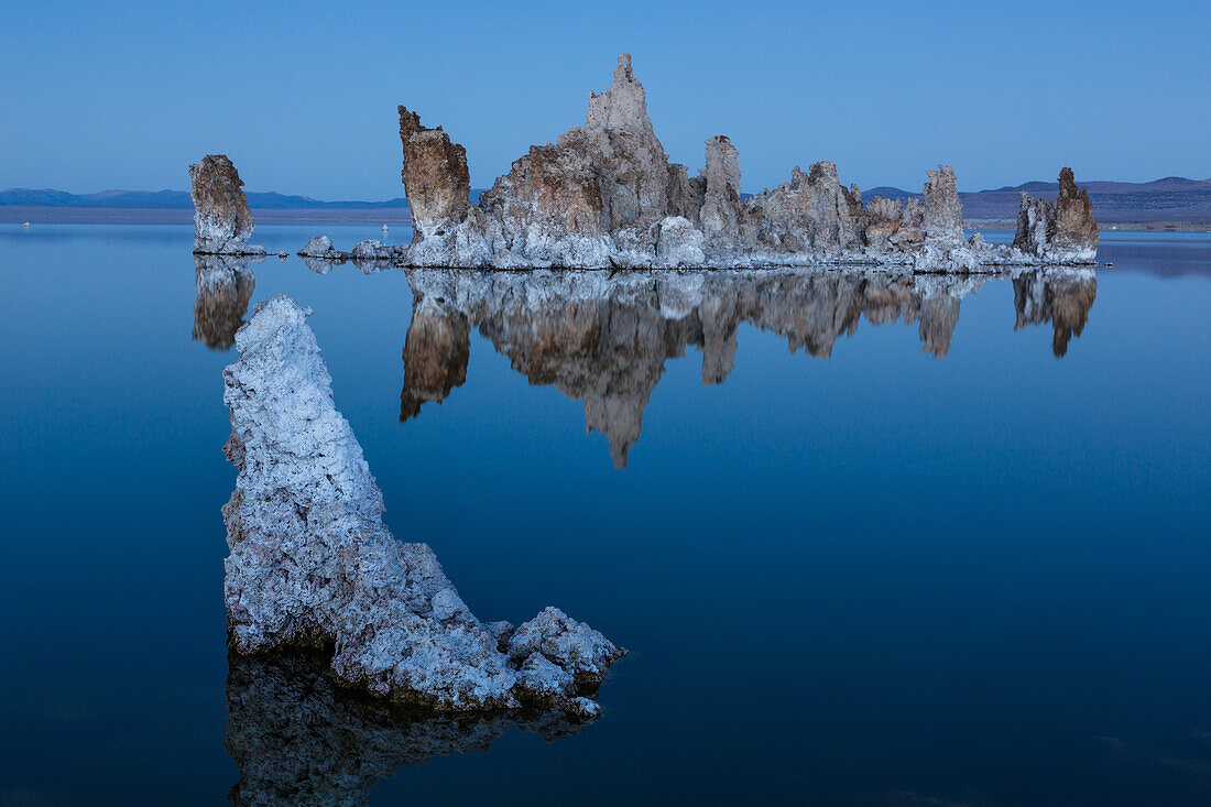 Tufa formations reflected in Mono Lake in California in evening twilight.