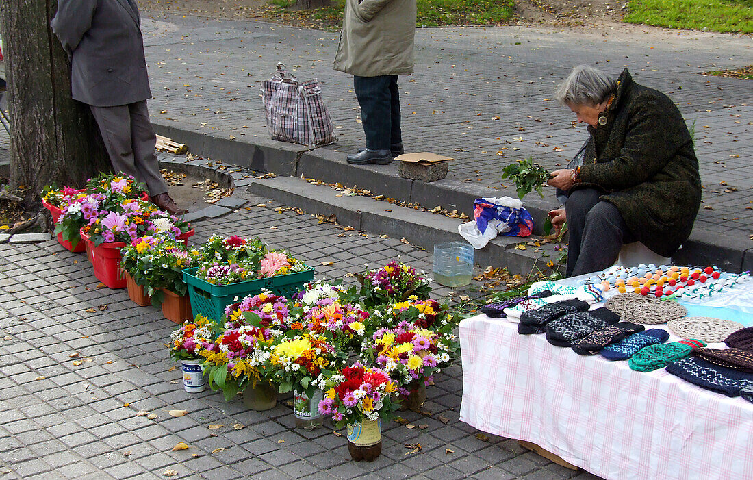 A woman sells flowers in a street market in the Old Town of Vilnius, Lithuania. A UNESCO World Heritage Site.