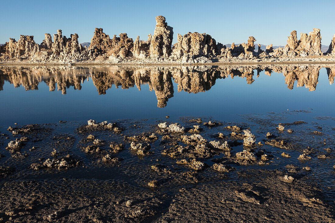 Tufa rock formations reflected in Mono Lake in California.