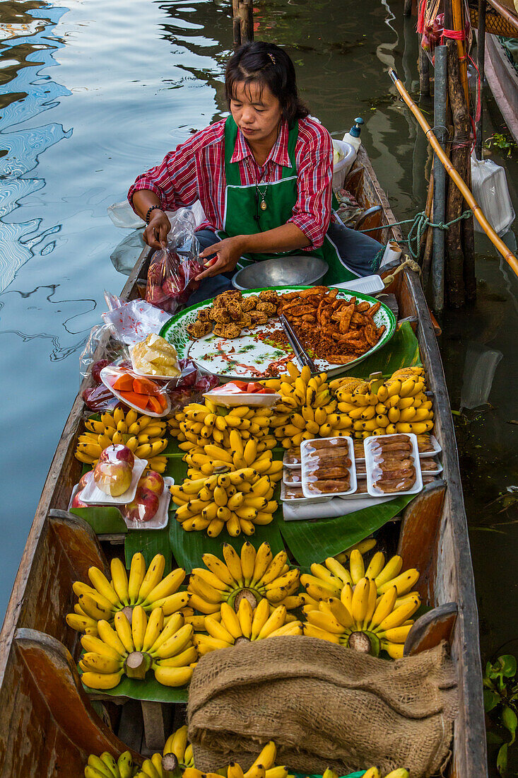 A Thai woman preparing food on her boat in the Damnoen Saduak Floating Market in Thailand.