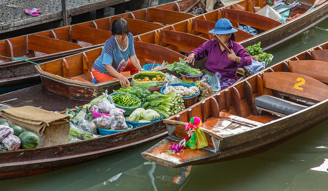 Soziale Interaktion zwischen thailändischen Verkäufern auf ihren Booten auf dem schwimmenden Markt von Damnoen Saduak in Thailand