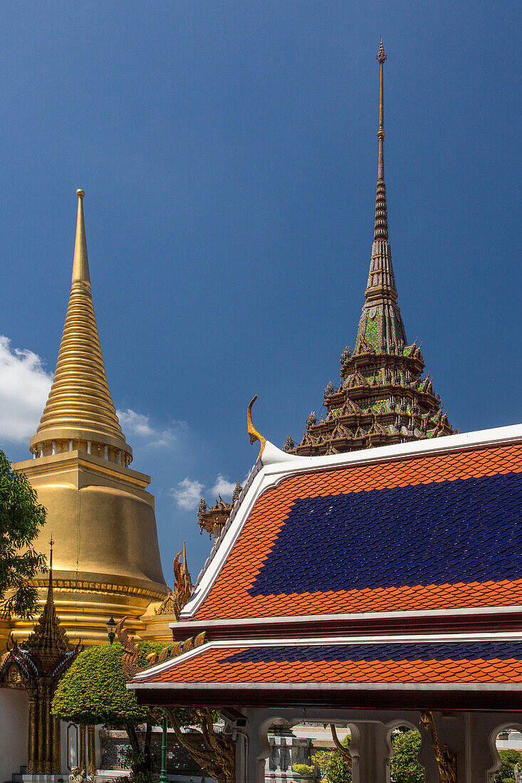 Spires of Phra Sri Ratana Chedi & Phra Mondhop by the Temple of the Emerald Buddha at the Grand Palace complex in Bangkok, Thailand.