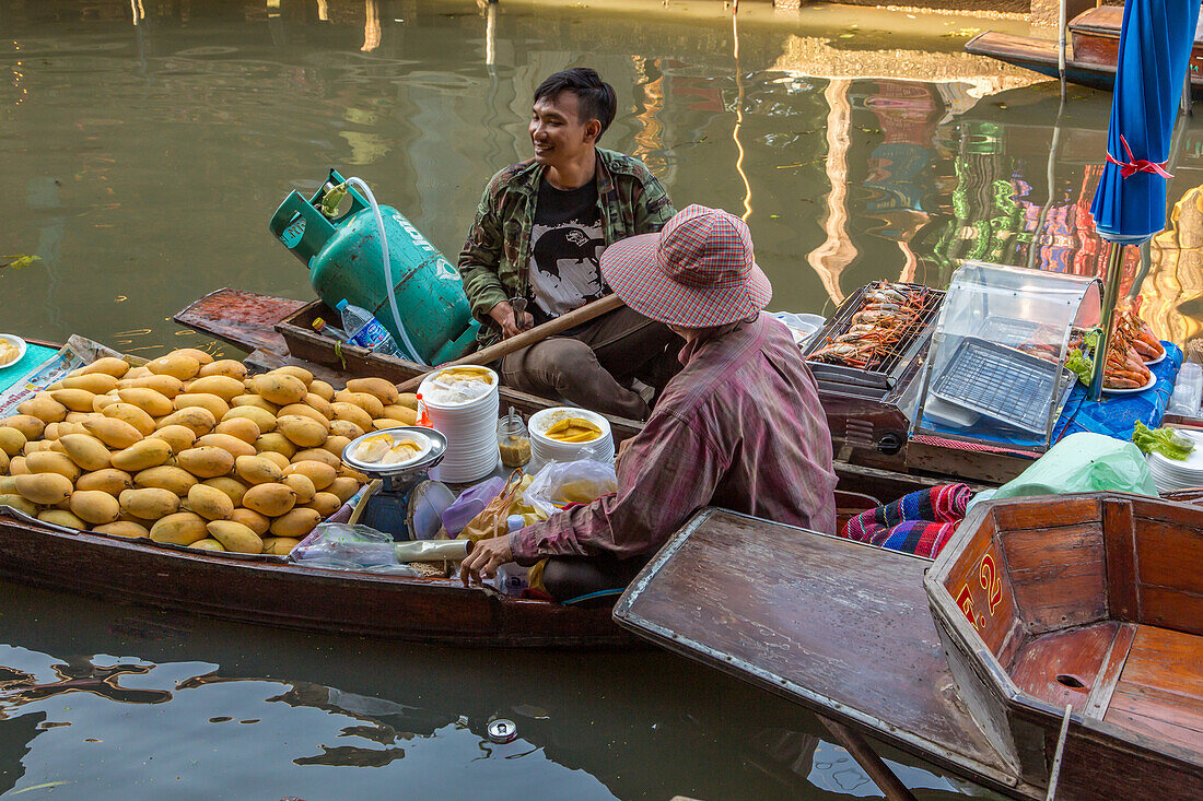 Thailändische Verkäufer auf ihren schwimmenden Küchenbooten auf dem Damnoen Saduak Floating Market in Thailand