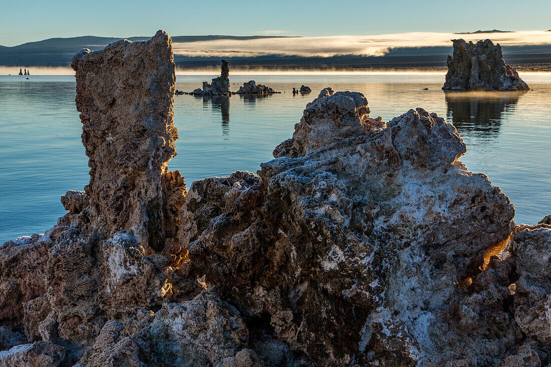 Tuffsteinformationen im Mono Lake in Kalifornien bei Sonnenaufgang mit Nebel im Hintergrund