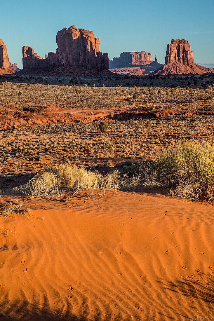 Red sand dunes and sandstone monuments in the Monument Valley Navajo Tribal Park in Arizona.