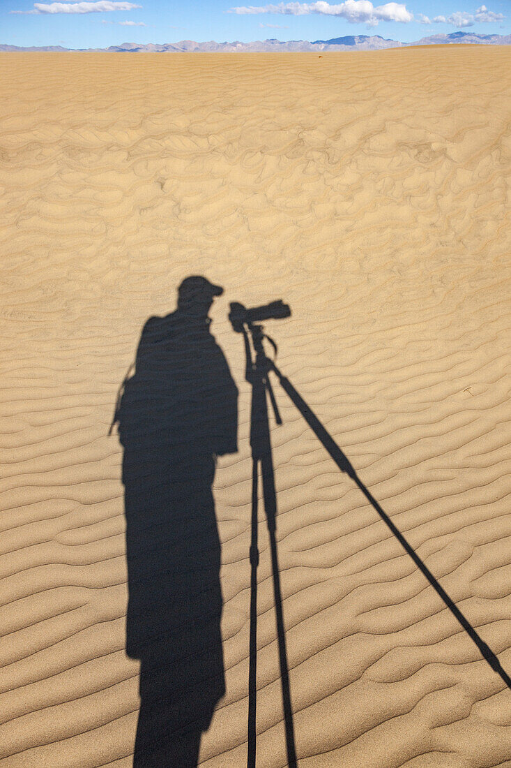 Ein Schatten-Selbstporträt in den Mesquite Flat Sanddünen in der Mojave-Wüste im Death Valley National Park, Kalifornien