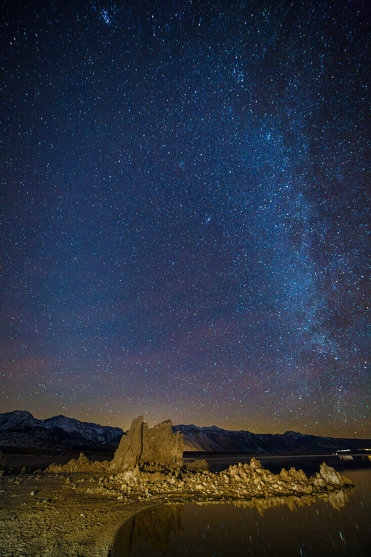 Milchstraße über Tuffsteinformationen im Mono Lake in Kalifornien mit Sternen, die sich im See spiegeln