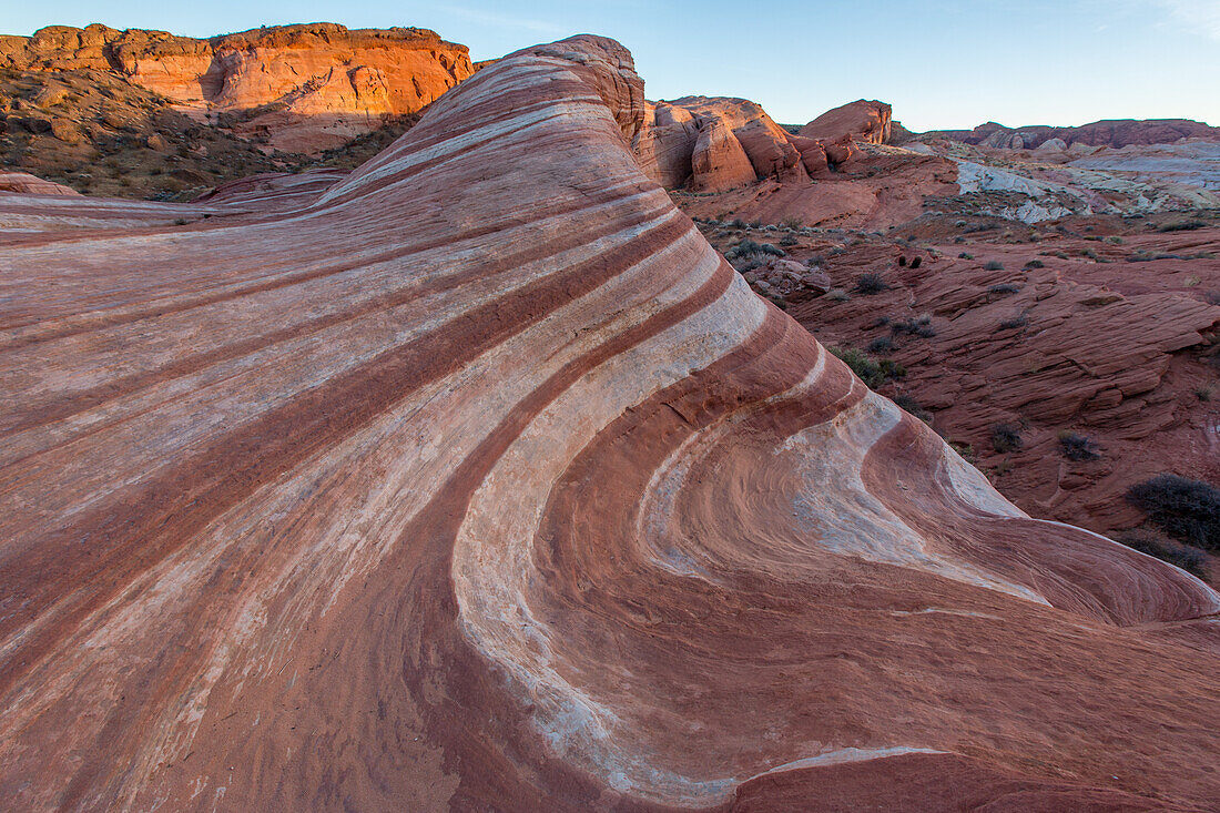 The Fire Wave, a red & white striped Aztec sandstone formation in pastel light at sunset in Valley of Fire State Park, Nevada.