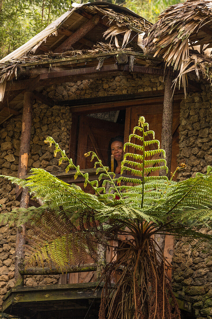 A Dominican woman looks out the door of her home in the hills near Constanza in the Dominican Republic.