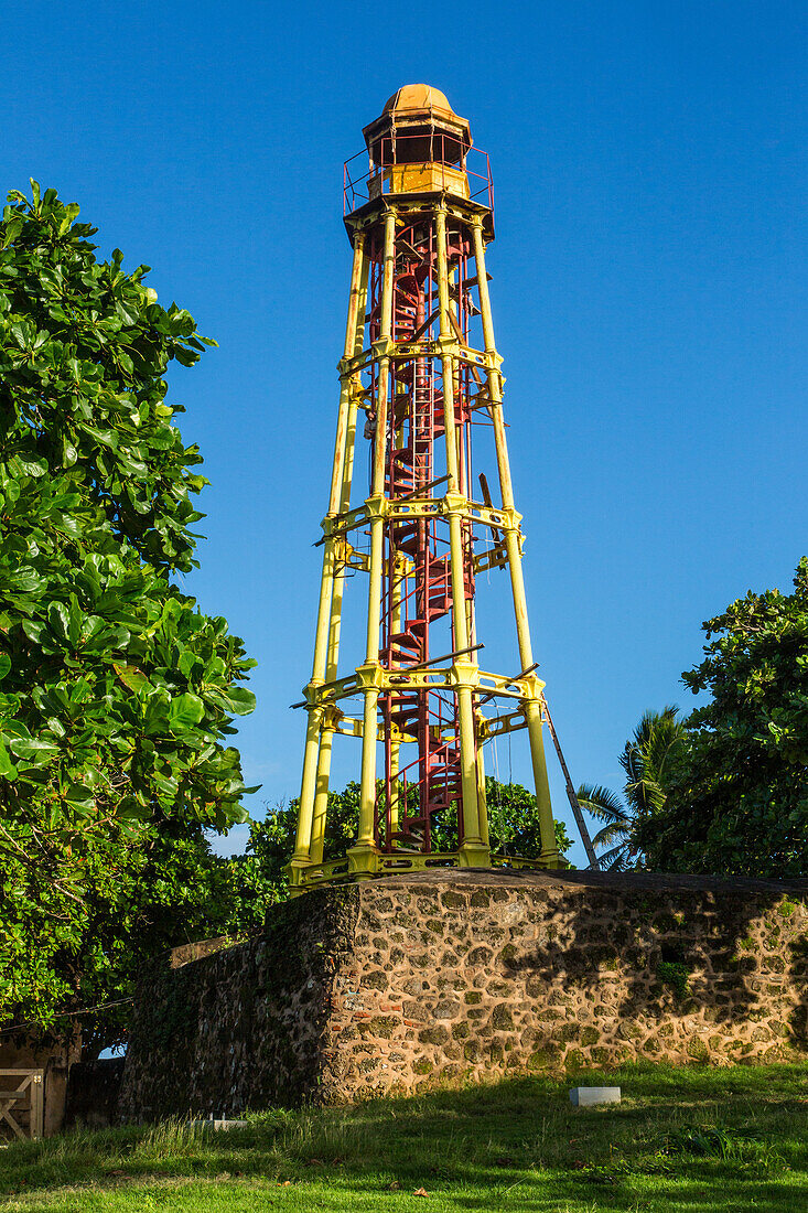 Der gusseiserne Leuchtturm von Puerto Plata wurde 1879 im heutigen La Puntilla Park in Puerto Plata, Dominikanische Republik, erbaut. Er ist 24,38 Meter hoch. Im Vordergrund ist ein Amphitheater im Park zu sehen.