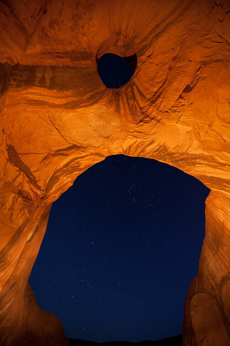 The Orion constellation through the Big Hogan Arch at night in the Monument Valley Navajo Tribal Park in Arizona.