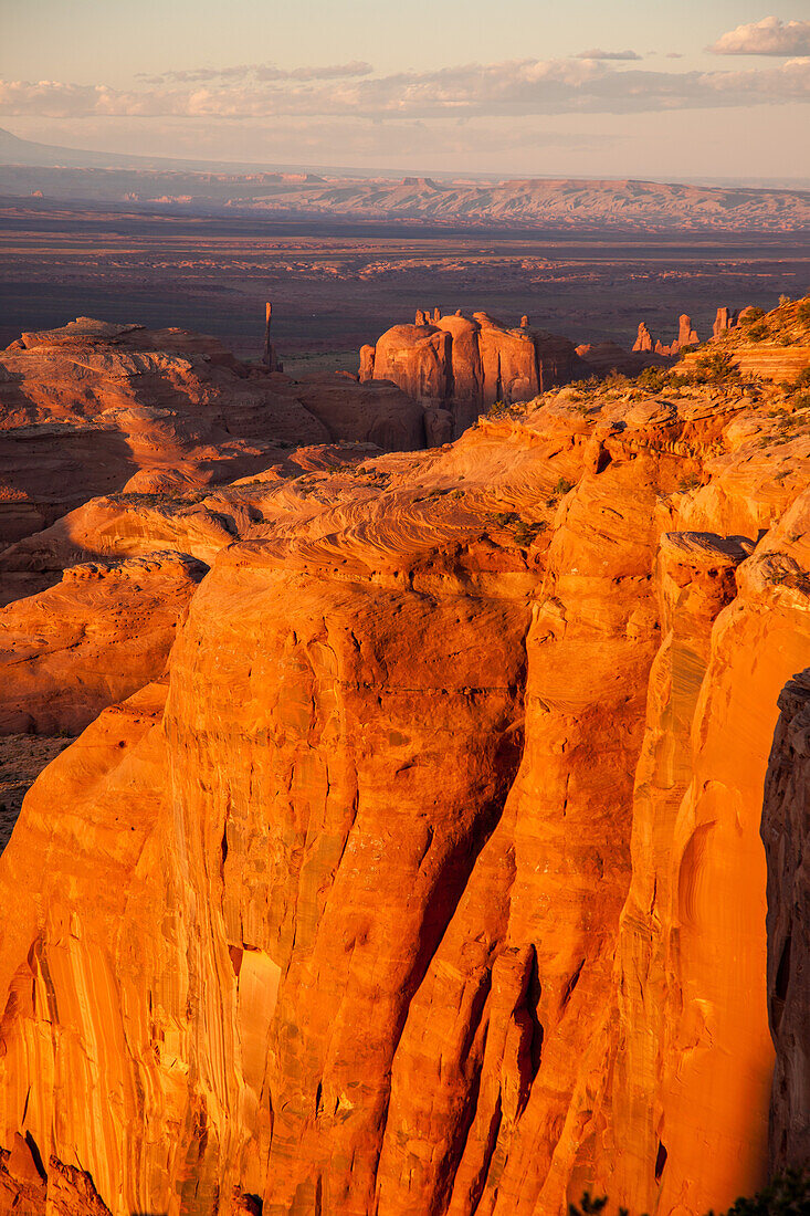Sonnenuntergangslicht auf den Sandsteinformationen im Monument Navajo Valley Tribal Park in Arizona. Blick von Hunt's Mesa. Die Abajo Mountains und die Bear's Ears, links, in der Ferne