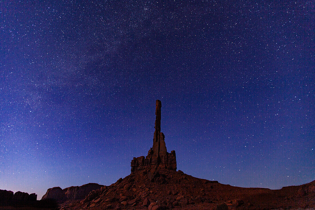 Stars over the moonlit Totem Pole at night in the Monument Valley Navajo Tribal Park in Arizona.