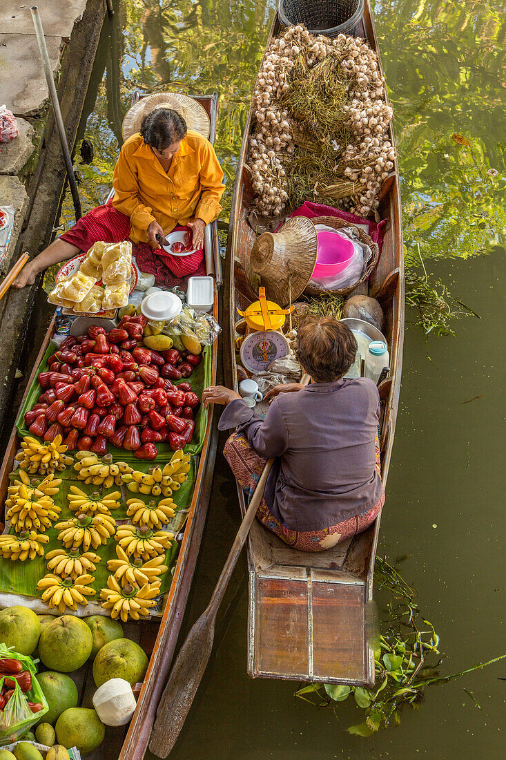 Soziale Interaktion zwischen thailändischen Verkäufern auf ihren Booten auf dem schwimmenden Markt von Damnoen Saduak in Thailand