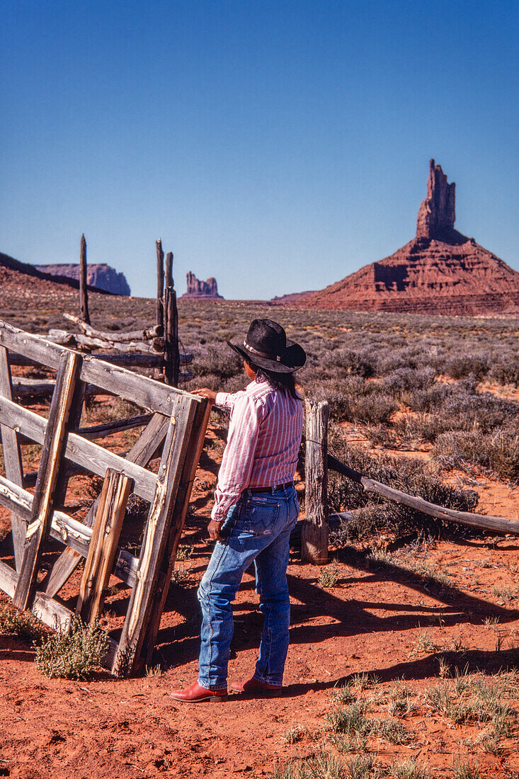 Ein Navajo-Cowboy an einem Korral-Tor im Monument Valley Navajo Tribal Park in Arizona