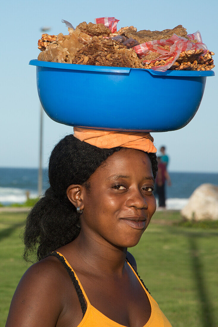 Eine junge haitianische Einwanderin verkauft Süßigkeiten im Park von Puntilla del Malecon, Puerto Plata, Dominikanische Republik