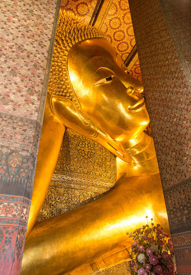 The giant Reclining Buddha statue, gilded with gold leaf, in the Wat Pho Temple in Bangkok, Thailand.