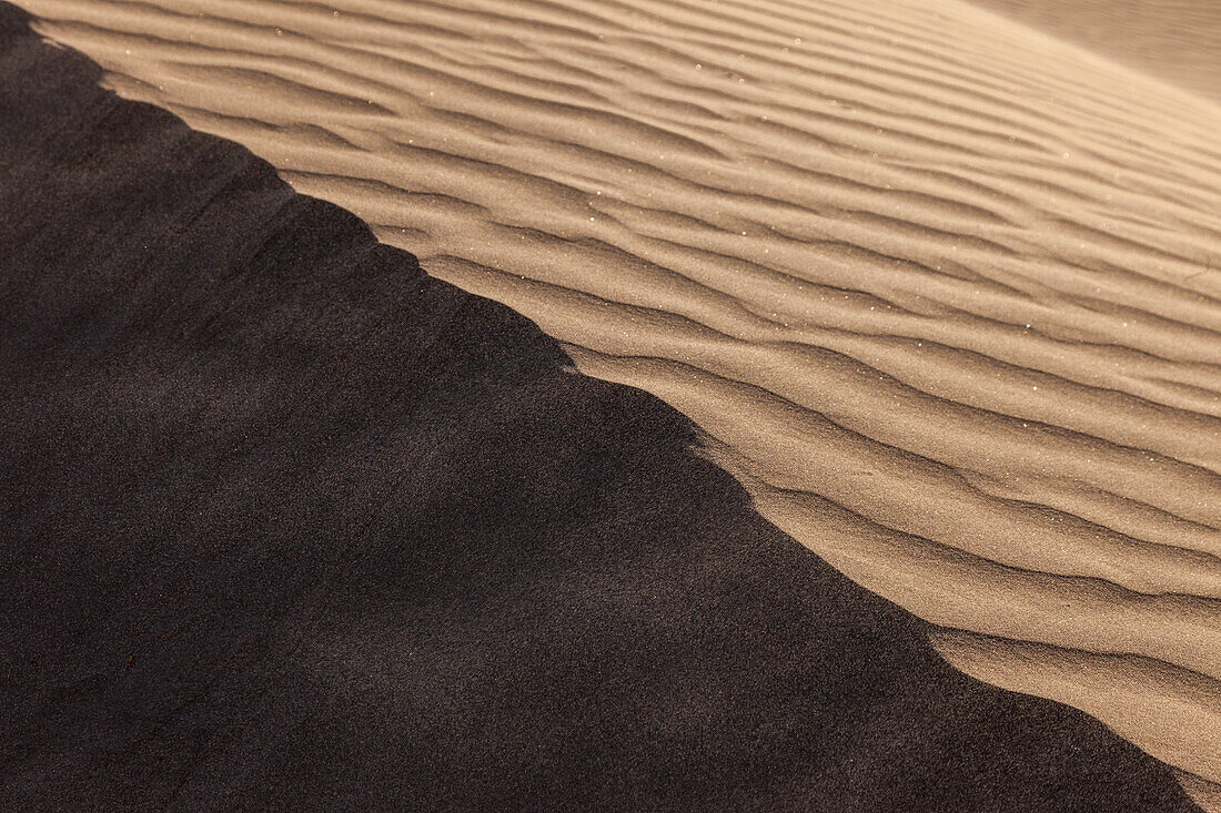 Shadowed crest of a dune in the Mesquite Flat Sand Dunes in the Mojave Desert in Death Valley National Park, California.