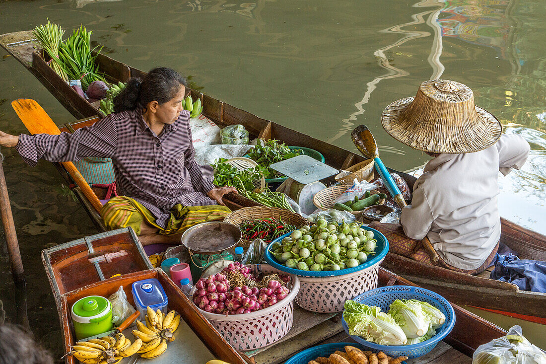 Soziale Interaktion zwischen thailändischen Verkäufern auf ihren Booten auf dem schwimmenden Markt von Damnoen Saduak in Thailand