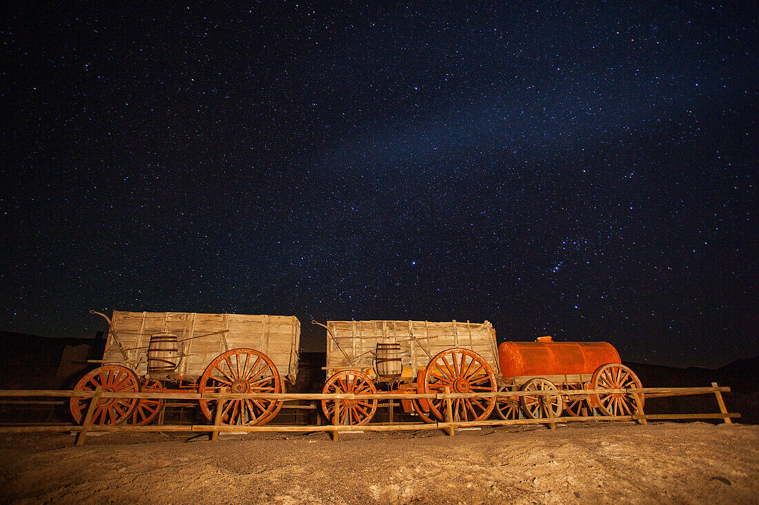 Historic 20-mule team borax ore hauling wagon on display at night at Furnace Creek in Death Valley National Park in California.
