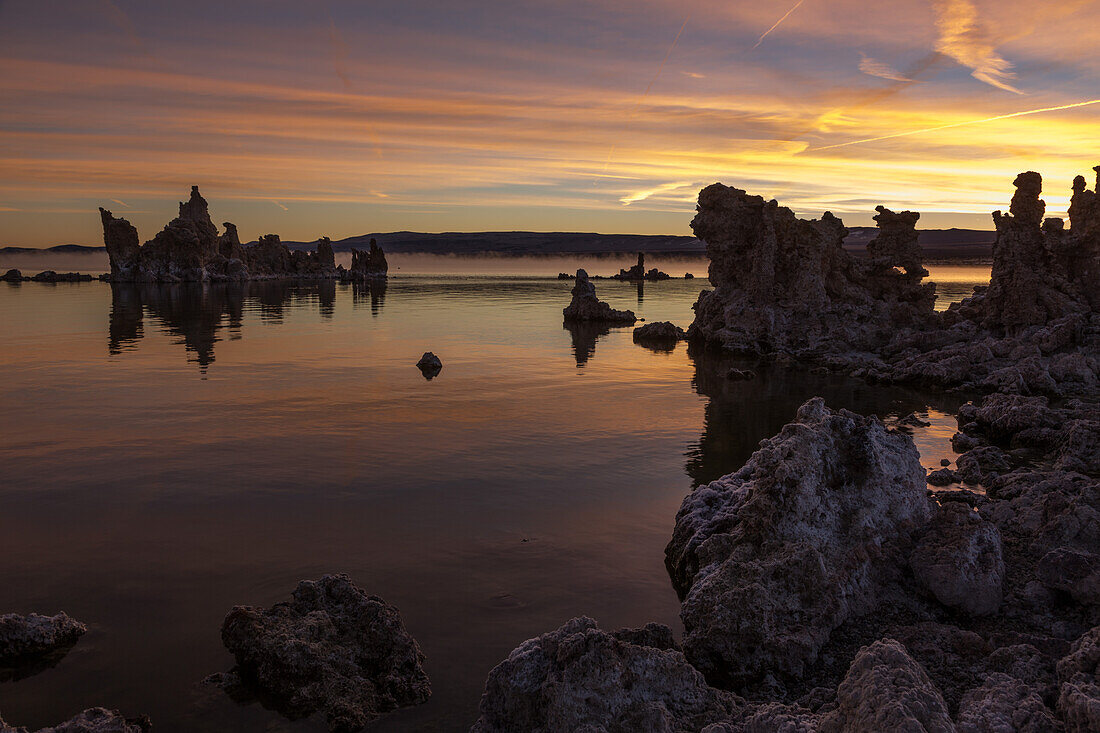 Farbenfrohe Sonnenaufgangsansichten von Tuffsteinformationen im Mono Lake in Kalifornien. Man beachte den Nebel auf der Seeoberfläche im Hintergrund