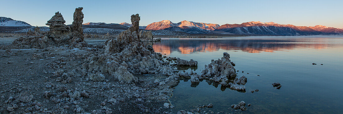 Tufa formations in Mono Lake in California at dawn with the Eastern Sierra Mountains in the background.