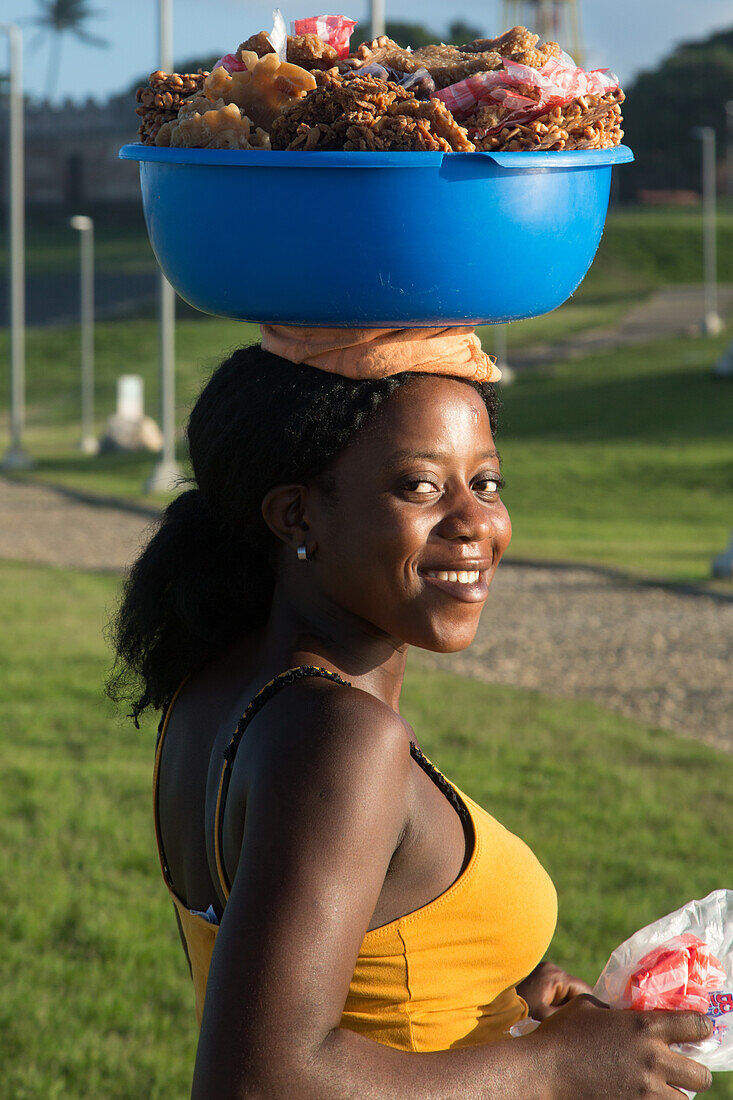 A young Haitian immigrant woman selling candy in the park at Puntilla del Malecon, Puerto Plata, Dominican Republic.