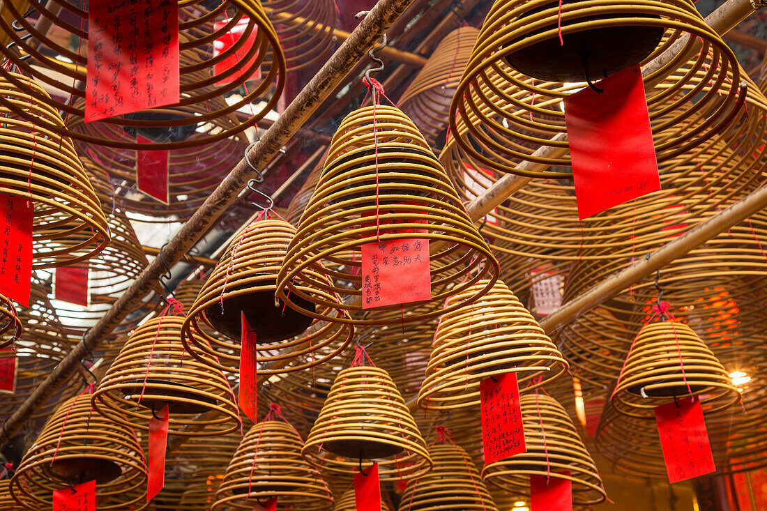 Burning incense coils send prayers to heaven in the Man Mo Temple, a Buddhist temple in Hong Kong, China.