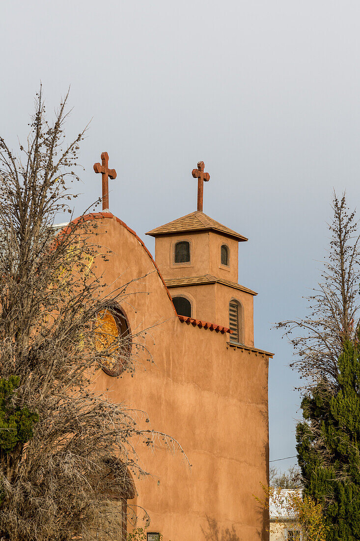 The bell towers & facade of the old mission-style Catholic parish church in San Antonio, a small town in rural New Mexico.