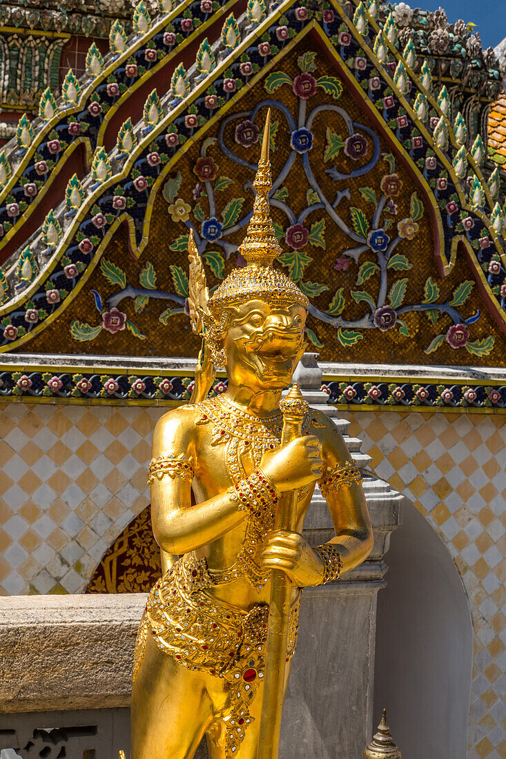 Golden statue of a Singhaphanon mythical creature guards the Phra Wiharn Yod in the Grand Palace complex in Bangkok, Thailand. A Singhaphanon has the upper body of a monkey and lower body of a lion.